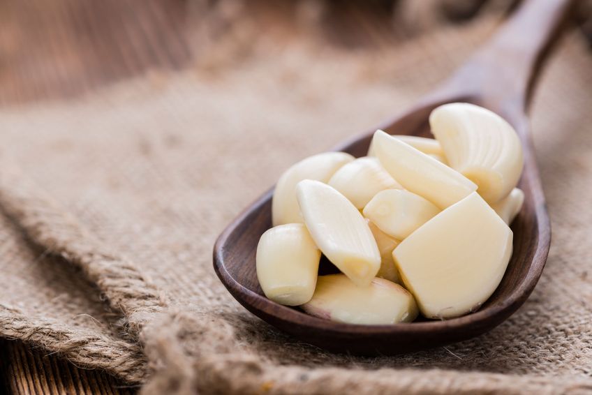 Wooden Spoon with Garlic (close-up shot) on vintage background